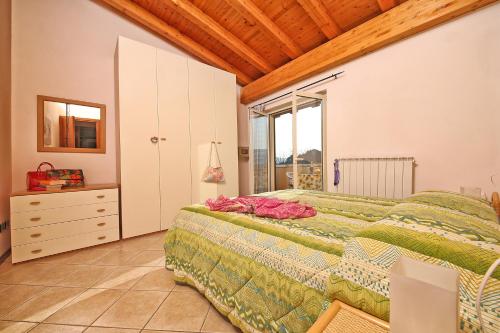 a bedroom with a bed and a dresser and a window at Il Colombaro in Salò
