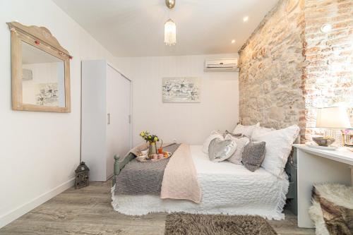 a bedroom with a bed and a stone wall at Rooms Tomic in Split