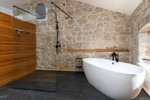 a bathroom with a tub and a glass shower at Apartments Casanova in Vrsar