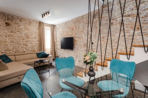 a living room with a couch and blue chairs at Apartments Casanova in Vrsar