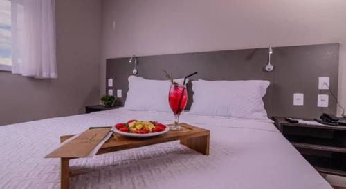 a bowl of fruit and a drink on a bed at Ramada by Wyndham Manaus Torres Center in Manaus