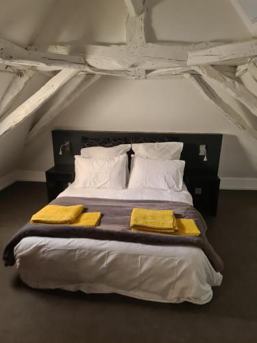 ein Schlafzimmer mit einem großen Bett mit gelben Decken und Kissen in der Unterkunft GITE AU ROC DE BOURZAC AVEC PISCINE PRIVÉE in Bayac