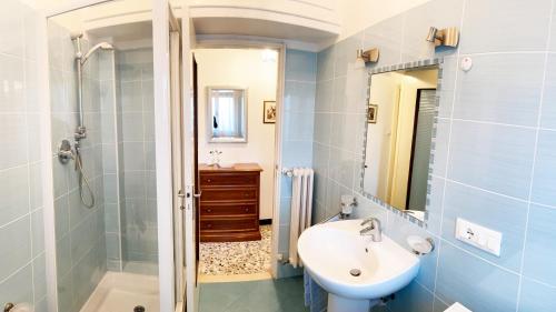 bagno con lavandino, doccia e specchio di IN VILLA Relax a 200 metri da mare e centro a Loano