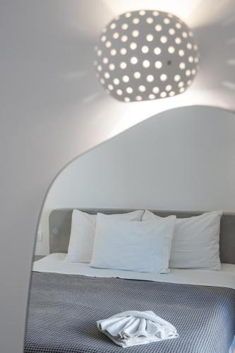 a bed with white pillows and a light above it at Anna's in Karterados