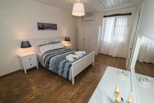 um quarto com uma cama e uma mesa com 2 candeeiros em Avli Townhouse em Panormos Skopelos