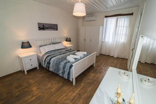 een slaapkamer met een bed en een tafel met 2 lampen bij Avli Townhouse in Skopelos Town