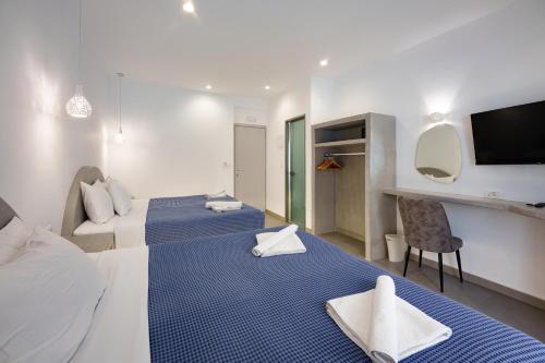 ein Hotelzimmer mit 2 Betten und einem TV in der Unterkunft Anna's in Karterados