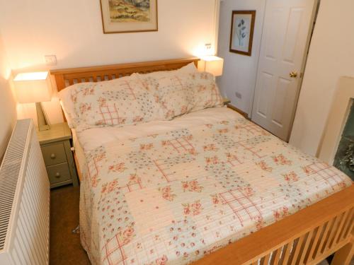 a bedroom with a bed with a comforter on it at Sunny Cottage in Darlington