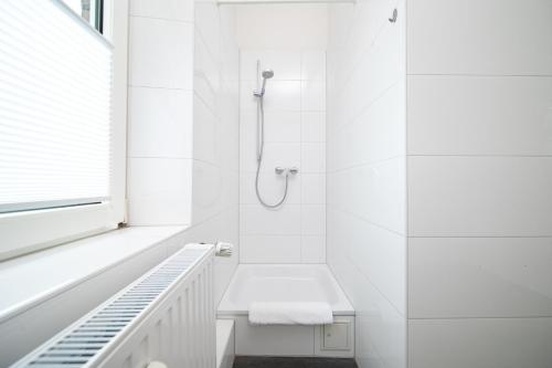 a white bathroom with a shower and a toilet at Favorite Stays - Suite And More - Kitchen in Neuss