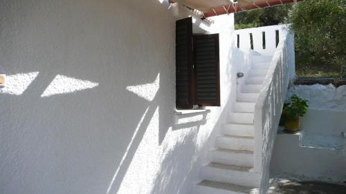 a staircase leading up to a white building with a window at Stefanos Garden in Arménoi