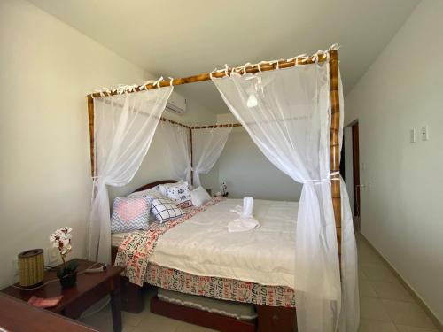 Casa Pé na Areia في ساو جوزيه دا كوروا غراندي: غرفة نوم بسرير مع مظلة
