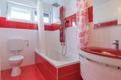 a red and white bathroom with a toilet and a sink at Vita Garden Apartment 85 m2 Private Entrance & 100 m2 Terrace in Pula