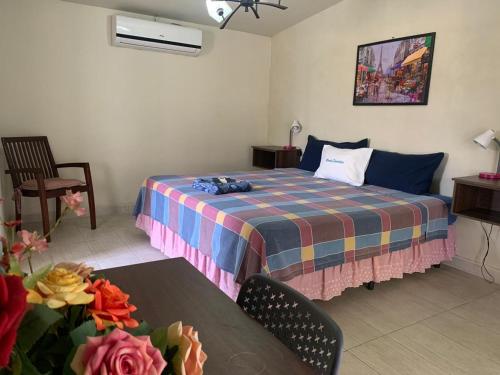 a bedroom with a bed and a table with flowers at Hotel y Restaurante Rincón Familiar in La Libertad