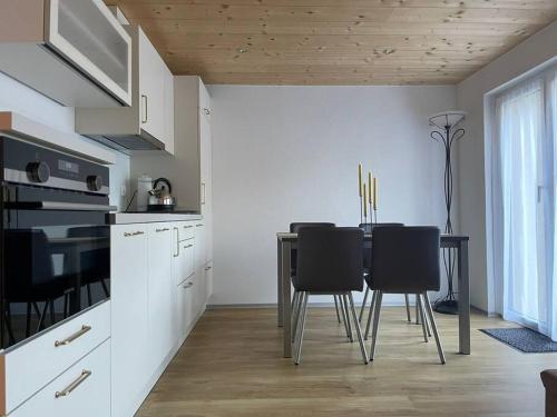 cocina con mesa y sillas negras en Apartment Bellavista en Saas-Grund