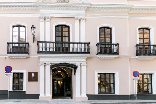a large white building with windows and balconies at Hotel Casa Palacio Don Ramón in Seville