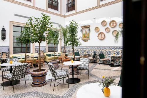 a restaurant with tables and chairs in a room at Hotel Casa Palacio Don Ramón in Seville