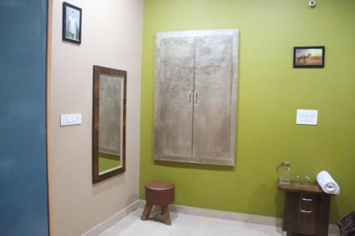a bathroom with green walls and a sink and a mirror at The Mehran way Homestay in Jodhpur