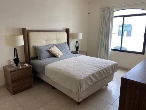 1 dormitorio con 1 cama con 2 lámparas y una ventana en Villa c-Netflix, Alberca y vista al Rio, en Veracruz