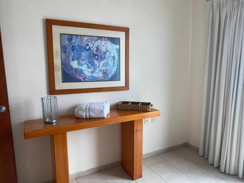 una mesa de madera en una habitación con una pintura en la pared en Villa c-Netflix, Alberca y vista al Rio, en Veracruz