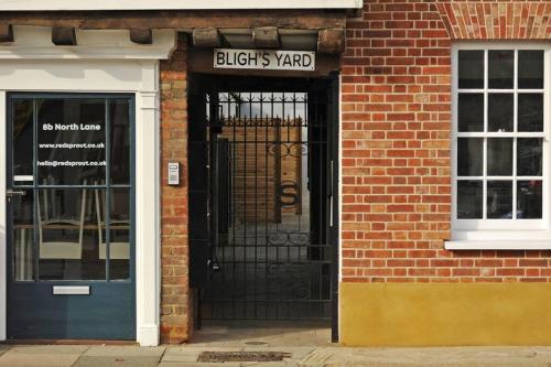 a door to a brick building with a black gate at No. 3 Bligh's Yard in Canterbury
