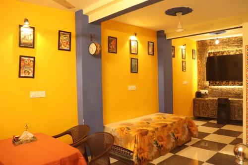 a yellow room with two tables and a bed at The Mehran way Homestay in Jodhpur