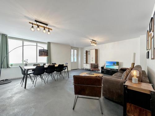 a living room with a couch and a table with chairs at Plein Coeur de la Vieille Ville de Sion in Sion