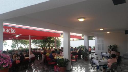 a group of people sitting at tables in a restaurant at Guest House Marko in Seline