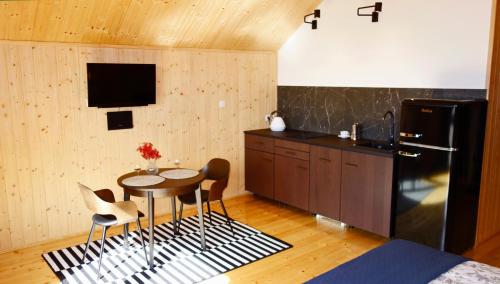 a kitchen with a table and chairs and a refrigerator at Dzikie Lisko - Apartament z klimatyzacją in Lesko