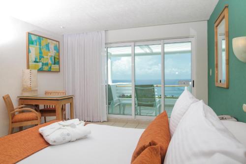 a bedroom with a bed with a view of the ocean at Casa Mexicana Cozumel in Cozumel