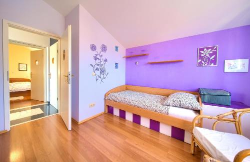 a bedroom with a bed and a purple wall at Luxury apartment Vanessa, Njivice in Njivice