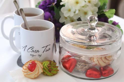 a cup of coffee and a jar of cookies and a cup of tea at A Casa Tua in Bologna