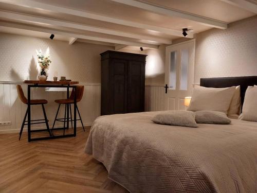 a bedroom with a bed and a table with a bar at B&B Mañana in Cuijk