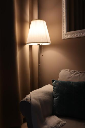 a lamp in the corner of a room with a couch at A Casa Tua in Bologna