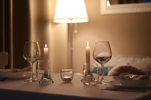 a table with three wine glasses and candles on it at A Casa Tua in Bologna