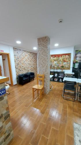 a living room with wooden floors and a table and chairs at Residencial Condado in Faro