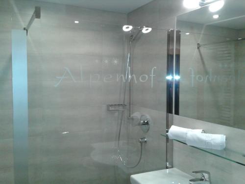a bathroom with a shower with a toilet and a sink at Alpenhof in Lermoos