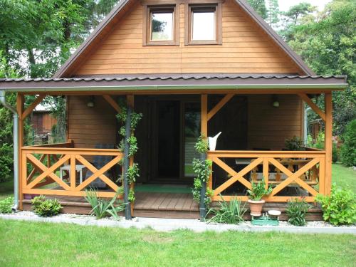 a wooden cabin with a porch and a door at Wilkaski zakątek in Giżycko