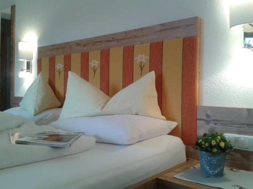 a hotel room with a bed with white pillows at Alpenhof in Lermoos