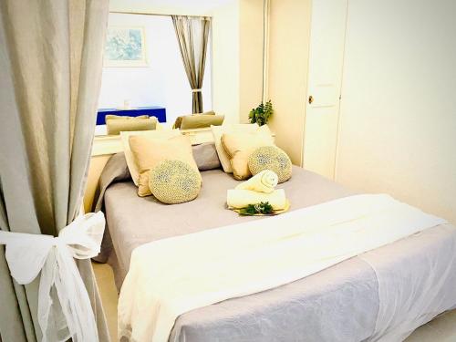 a bedroom with two beds with white sheets and pillows at Boho Chic on the Beach by Deihu Experiences in Playa de las Americas