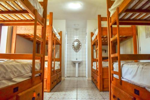 a room with four bunk beds and a sink at Hostel Poesia in Foz do Iguaçu