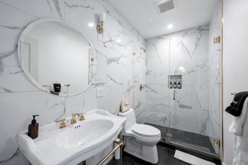 La salle de bains blanche est pourvue d'un lavabo et de toilettes. dans l'établissement Art Deco Townhouse in the Heart of Hollywood, à Los Angeles