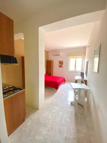 a kitchen and a living room with a red bed at Residence Hotel Felix in Ricadi