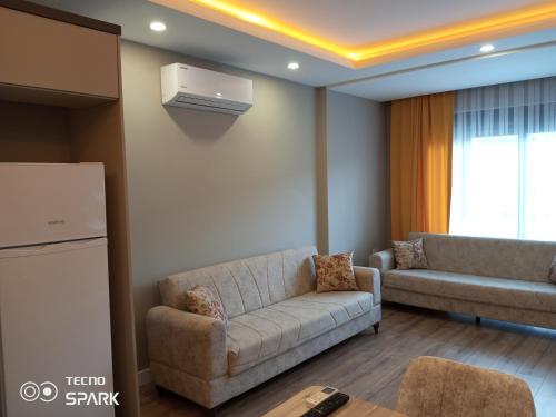 a living room with a couch and a refrigerator at Mali Garden Residence in Side