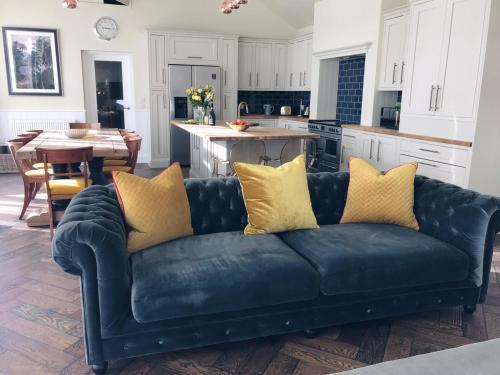 a black couch with yellow pillows in a kitchen at Gardeners cottage in Pitlochry