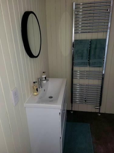 a bathroom with a white sink and a mirror at Gardeners Cottage at Balnakeilly Estate in Pitlochry