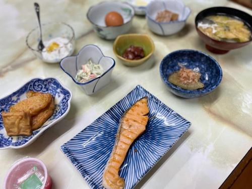 una mesa con platos de comida y tazones de comida en Ryokan Warajisha - Vacation STAY 67784v, en Goto