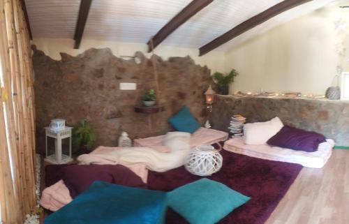 a room with two beds and a stone wall at La casa de los Bonales in Arroyomolinos de León