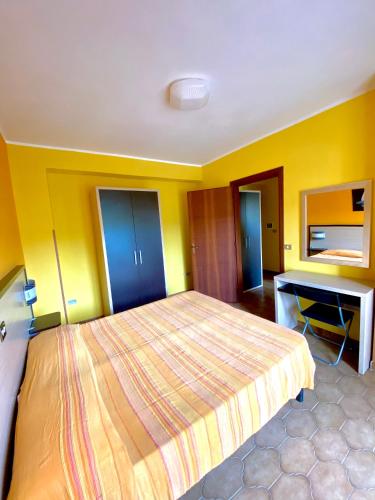 a bedroom with a large bed and a desk at Residence Hotel Felix in Ricadi