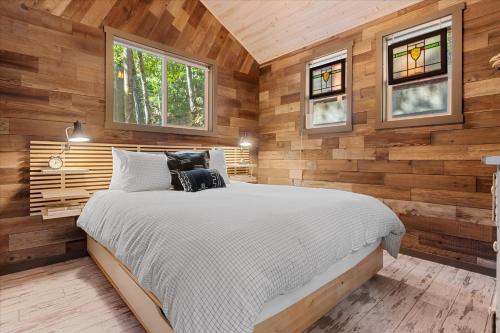 a bedroom with a bed in a wooden wall at Sydneys River Retreat in Guerneville