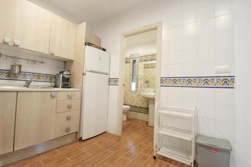 a kitchen with a white refrigerator and a sink at Un paso hacia el mar in Chipiona